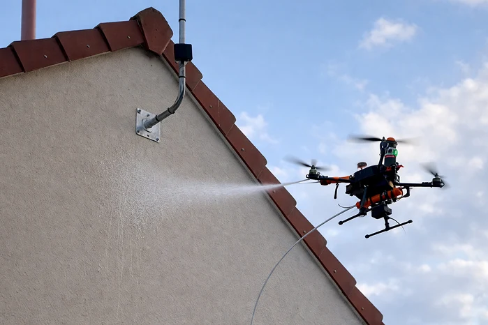 Drone nettoyant le haut d'une façade de maison